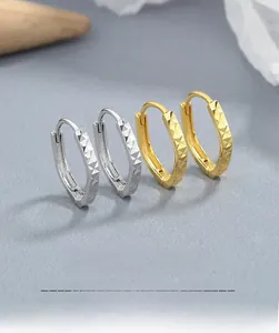 Detail of S925 sterling silver geometric hoop earrings with textured diamond-cut finish