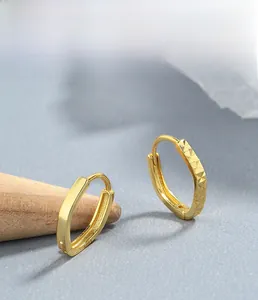 Detailed macro view of S925 sterling silver gold earrings with smooth and faceted textures