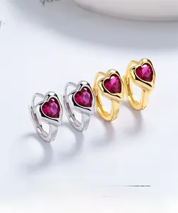 Macro detail of 925 silver heart earrings with rose red zircon in gold and silver finish
