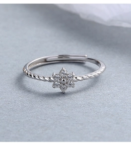 Macro detail of 925 silver flower ring with zircon stones and twisted band design