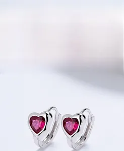 Macro detail of S925 sterling silver hoop earring with heart-cut rose red zircon