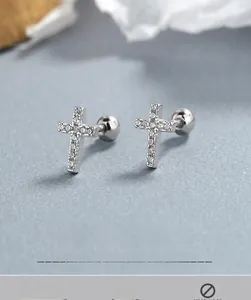 Détail macro de boucles d'oreilles croix en argent 925 avec fermoir à vis et zircons