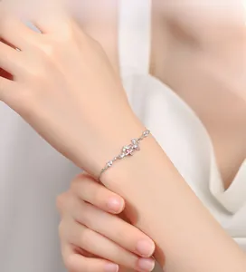 Détail du bracelet papillon en argent avec émail rose et zircons sur le poignet d'une femme