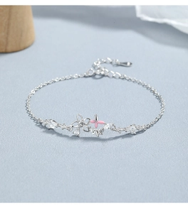 Détail du bracelet en argent avec papillon en émail rose et breloque fleur en zircon