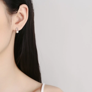 Créoles minimalistes en argent 925 avec perles, portées par un mannequin sur un fond gris clair