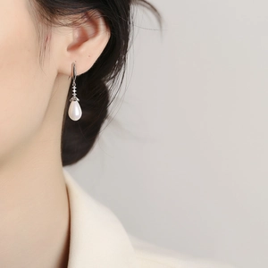 Elegant 925 sterling silver drop pearl earrings with subtle zircon accents on a model