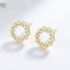 Macro view of gold-plated 925 silver stud earrings with sparkling cubic zirconia pavé setting