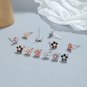 Detailed view of small 925 silver floral stud earrings with enamel petals and zircon center