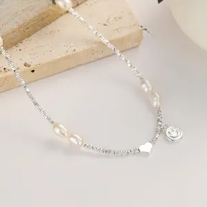 Detail of silver heart and smiley face pendants with baroque pearls on a bead chain