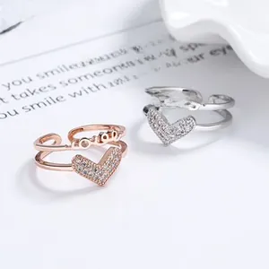 Détail d'une bague double couche cœur avec lettrage love et zircon en or rose et argent