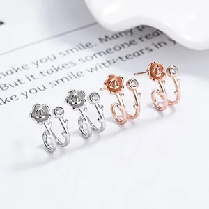 Detailed view of silver and rose gold floral twig stud earrings with small zircon gems