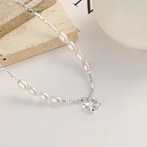 Close-up of 925 sterling silver pearl necklace with an elegant metal bow pendant