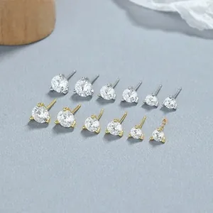Dettaglio di orecchini a lobo con zirconi tondi in argento e oro, diverse misure da 3 a 8 mm