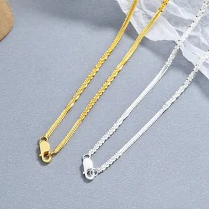 Detailed close-up of flat snake bone chain in gold and silver with lobster clasp