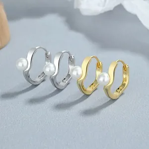 Détails macro de boucles d'oreilles créoles en argent 925 avec perles dorées et argent