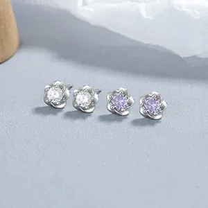 Macro detail of 925 sterling silver flower earrings with white and purple zircon stones