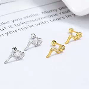 Macro detail of snake-shaped silver and gold earrings with pavé cubic zirconia