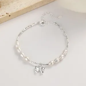 Macro detail of 925 silver irregular pearl bracelet with polished bow knot pendant