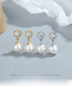 Détail de boucles d'oreilles perles rondes pavées de diamants en argent et or