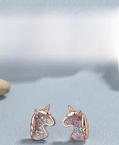Macro detail of rose gold unicorn earrings made of S925 silver with glitter enamel fill