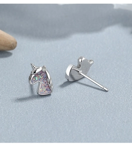 Close-up of 925 sterling silver unicorn stud earrings with pink glitter enamel finish