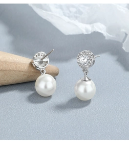 Vue macro détaillée de boucles d'oreilles en argent S925 avec diamants et perles blanches