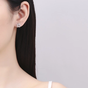 Minimalist 925 sterling silver star stud earrings with white zircon on a model