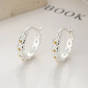 Close-up of S925 sterling silver daisy hoop earrings with embossed flower patterns