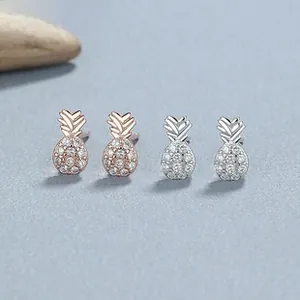 Macro detail of silver and rose gold pineapple stud earrings with micro zircon pavé