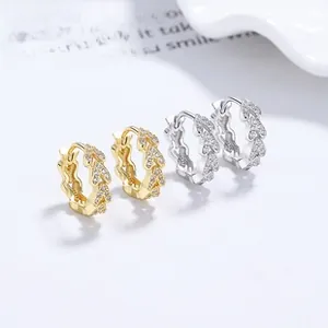 Macro detail of V-shaped wheat ear earrings in gold and silver with cubic zirconia