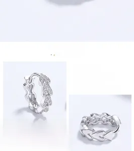 Macro detail of 925 sterling silver heart-shaped ear hoop with cubic zirconia stones