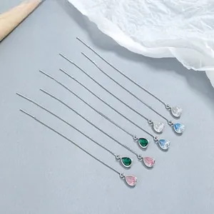 Détail de boucles d'oreilles pompon en argent 925 avec pendentifs en cristal coloré