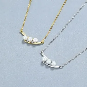 Détail de colliers en argent 925 en forme de V avec trois perles en finitions or et argent
