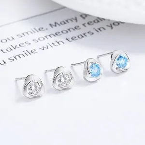 Gros plan sur des boucles d'oreilles en argent 925 avec pierres rondes claires et bleues