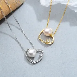 Dettaglio delle collane con cuore e perle in oro e argento con piccoli zirconi