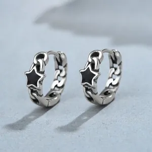 Macro view of vintage 925 silver lotus earrings featuring chain texture and black star charm