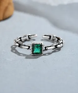 Detailed close-up of a vintage 925 sterling silver chain ring with emerald green square stone