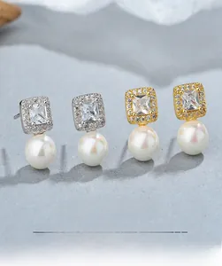 Detailed view of square diamond pearl earrings in gold and silver finishes