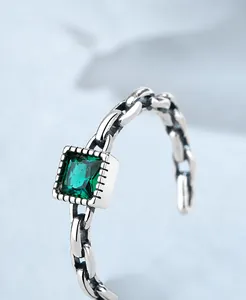 Macro detail of S925 sterling silver chain texture ring with square green gemstone