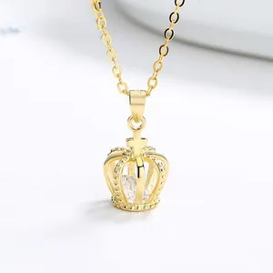 Macro shot of gold crown pendant with center zircon and cross detail on fine chain