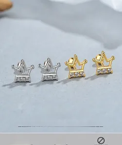 Detail of silver and gold crown stud earrings with three sparkling cubic zirconia stones