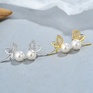 Detail of silver and gold clover pearl earrings with micro-inlaid zircon accents