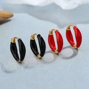 Dettaglio di orecchini a cerchio in argento 925 placcato oro con smalto rosso e nero