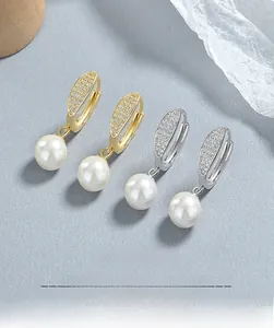 Vue macro des boucles d'oreilles créoles en argent S925 avec perles et zircons brillants