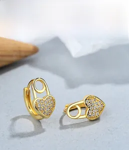Dettaglio macro di orecchini a cuore in argento S925 con placcatura in oro e zirconi