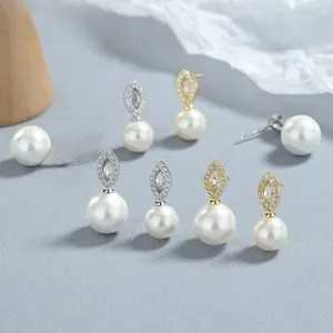 Close-up of 925 sterling silver pearl earrings with marquise-cut pavé diamonds details