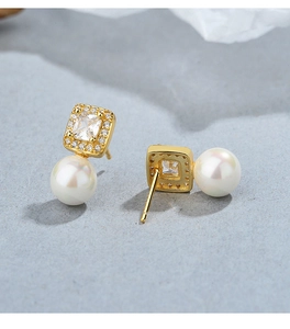 Detailed close-up of 925 silver pearl earrings with square cubic zirconia and gold plating