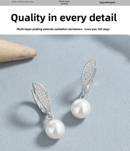 Détail de boucles d'oreilles en argent 925 avec perles et motif de feuilles pavées