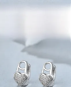 Dettaglio macro di orecchini a cuore in argento S925 con cristalli scintillanti e design a spilla