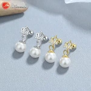 Detail showing gold and silver crown stud earrings with round pearls and screw backs